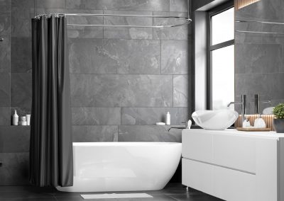 Modern bathroom with freestanding white bath, oversize grey tiles and white cabinetry