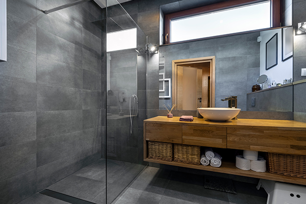 Modern bathroom with large floor to ceiling tiles, glass shower and timber vanity