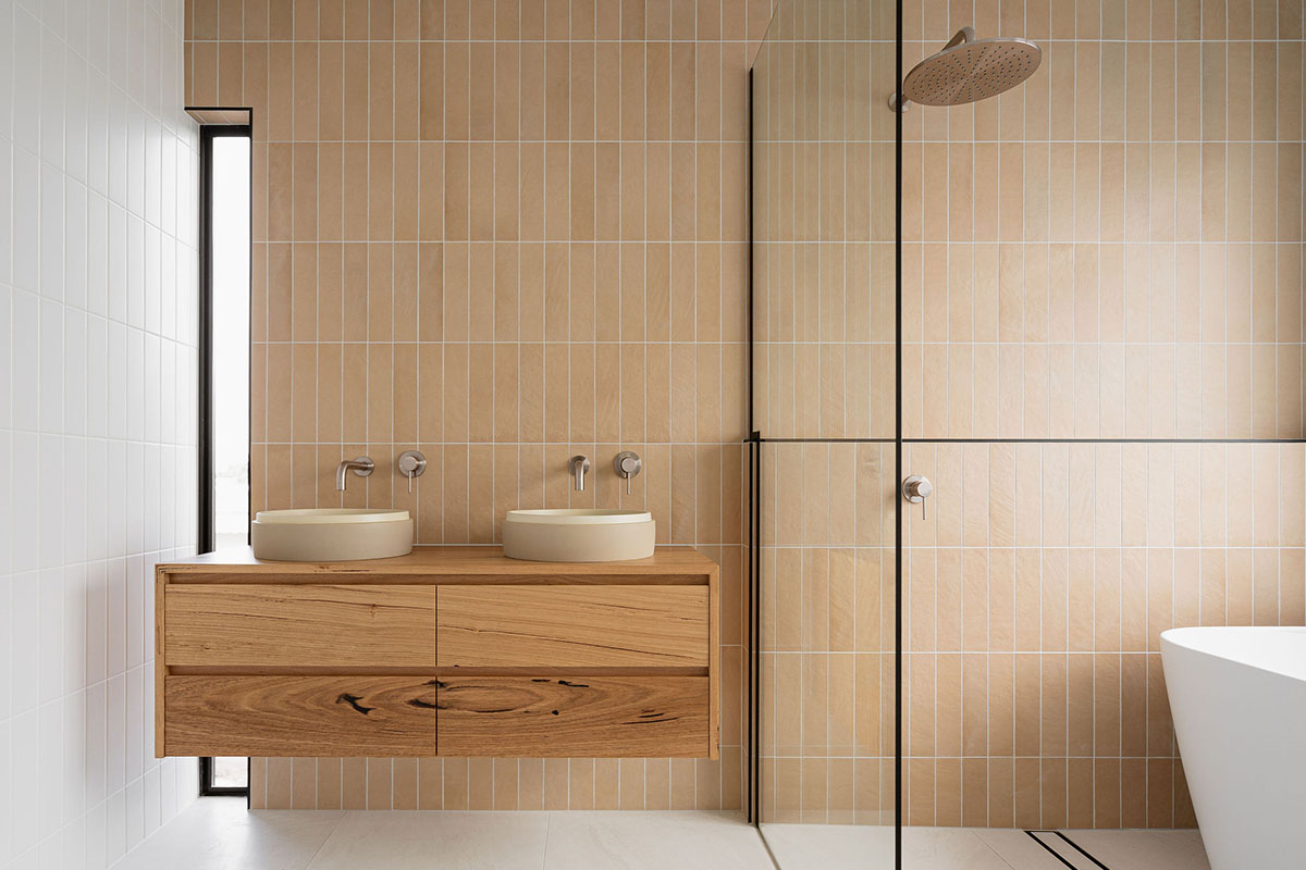 Luxury bathroom with vertical tiles, twin sinks and timber cabinetry
