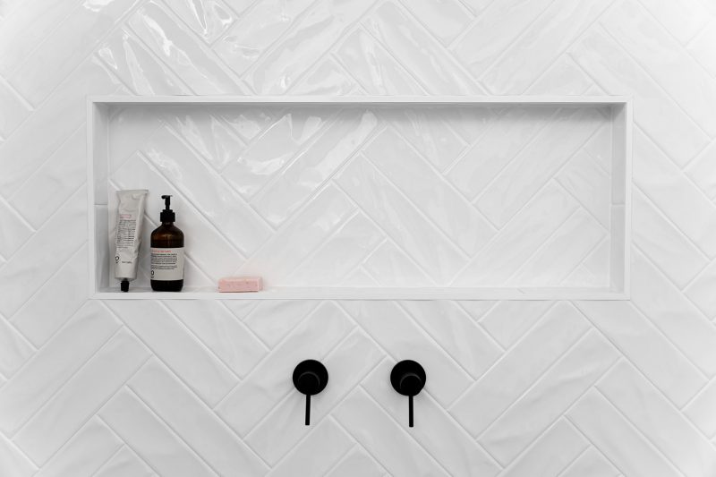 Double herringbone white tiles with shower niche and matt black tapware.